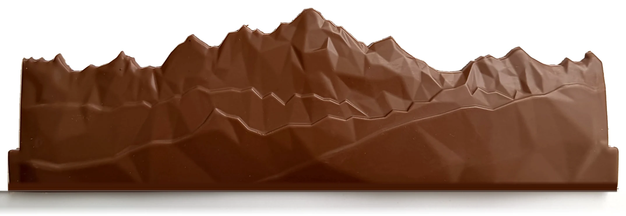 Le Massif du Mont Blanc en chocolat au lait, photographié de face sur fond blanc : la pièce entière, de la crête à la base, de l’Aiguille du Plan à l’Aiguille des Glaciers