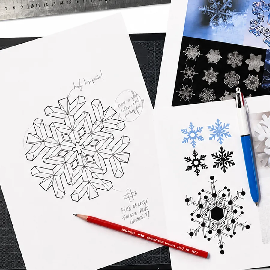 Croquis du Flocon au crayon, à côté de planches de flocons de neige